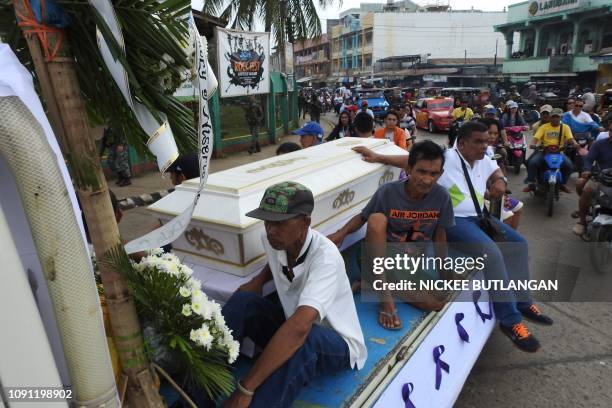 Mourners ride on a hearse during the funeral procession of a victim killed in the January 27 cathedral bombing in Jolo, Sulu province on the southern...