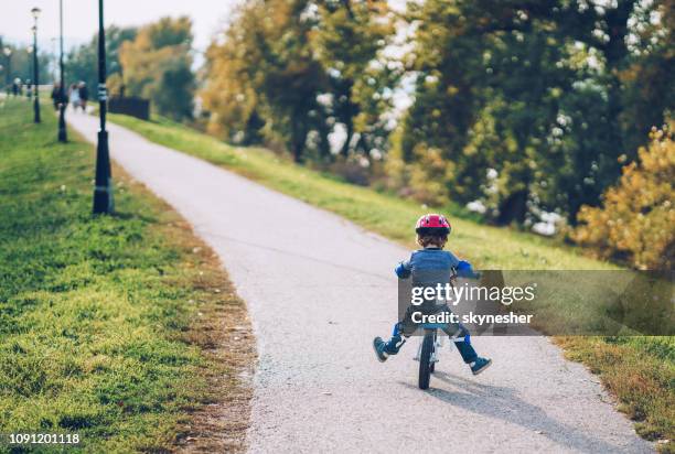 rückansicht der verspielte junge fahrrad und spaß im freien. - knieschützer stock-fotos und bilder
