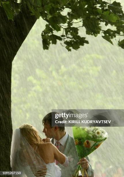 Just married couple braves the rain during the celebrations marking the Day of Love, Family and Fidelity in St. Petersburg on July 8, 2011. On July 8...