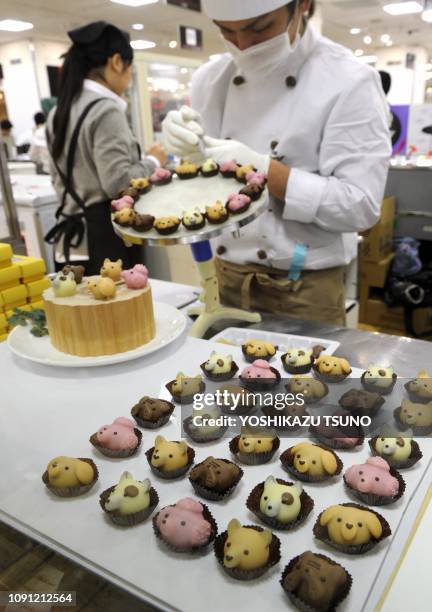 Japan's sweet shop Goncharoff chocolatier puts the finishing touches to animal-shaped chocolates at Takashimaya department store's Valentine's Day...