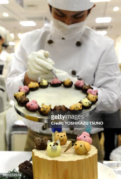 Japan's sweet shop Goncharoff chocolatier puts the finishing touches to animal-shaped chocolates at Takashimaya department store's Valentine's Day...