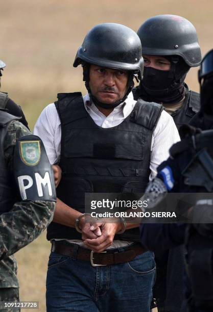 Members of the Honduran elite police unit Tigres and military police escort alleged Honduran drug trafficker Jose Adalid Amaya Argueta, at Campo de...