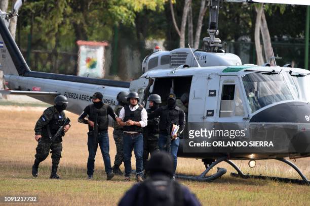 Members of the Honduran elite police unit Tigres and military police escort alleged Honduran drug trafficker Jose Adalid Amaya Argueta as he gets off...