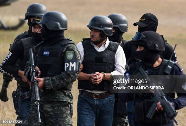 Members of the Honduran elite police unit Tigres and military police escort alleged Honduran drug trafficker Jose Adalid Amaya Argueta, at Campo de...