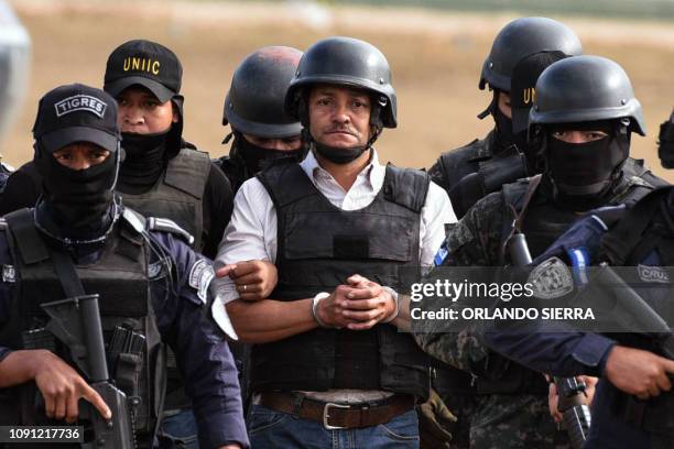 Members of the Honduran elite police unit Tigres and military police escort alleged Honduran drug trafficker Jose Adalid Amaya Argueta, at Campo de...