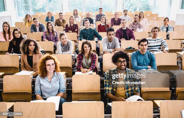 large group of happy college students in a lecture hall. - amphitheater stock pictures, royalty-free photos & images