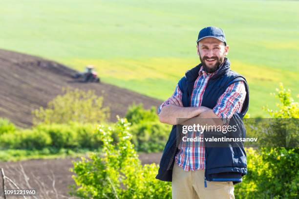 farmer standing arms crossed in cultivated field - farmer arms crossed stock pictures, royalty-free photos & images