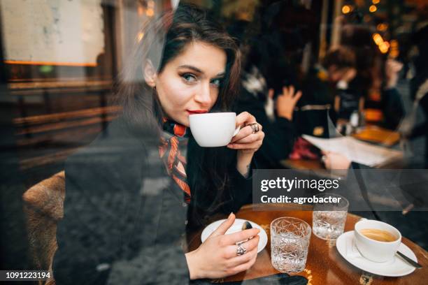 woman drinking coffee in cafe in paris, france - french women stock pictures, royalty-free photos & images