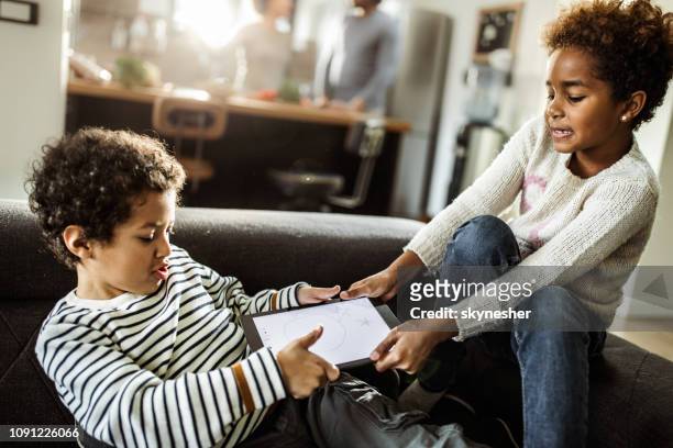 fighting over touchpad at home! - fighting stock pictures, royalty-free photos & images