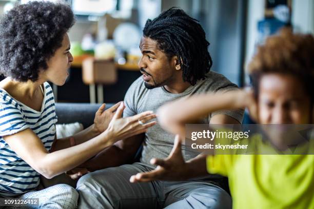 frustrated black parents arguing behind their daughter at home. - arguing blacks stock pictures, royalty-free photos & images