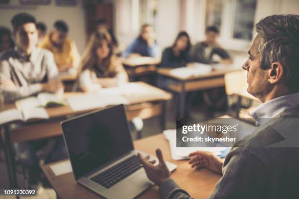serious professor teaching a lecture at high school. - edifício de educação imagens e fotografias de stock