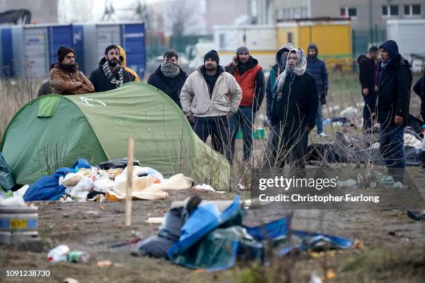 Migrants move their belongings as French police clear a migrant camp near Calais Port on January 08, 2019 in Calais, France. In recent weeks there...