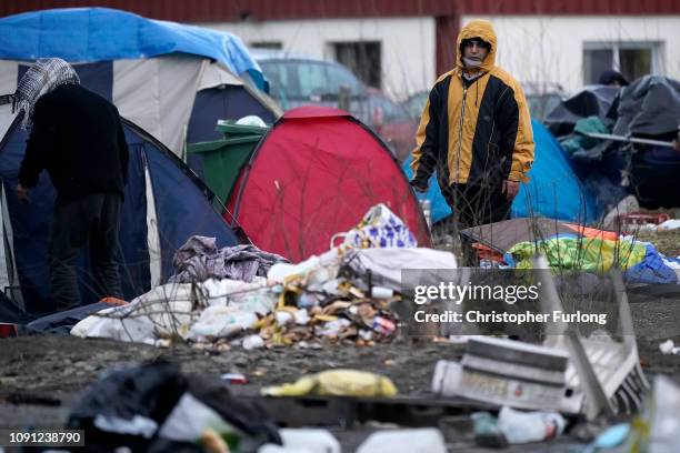 Migrants move their belongings as French police clear a migrant camp near Calais Port on January 08, 2019 in Calais, France. In recent weeks there...