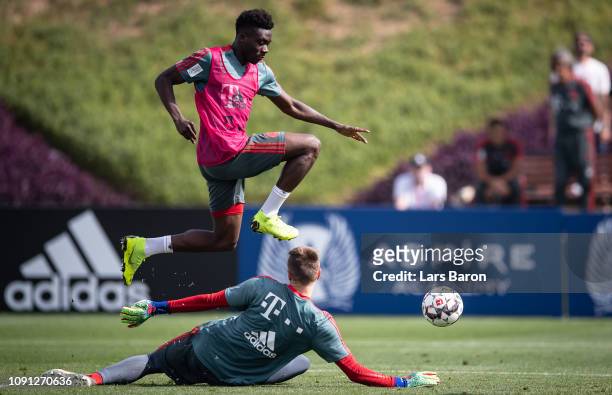 Alphonso Davies jumps over Christian Fruechtl during a training session at day five of the Bayern Muenchen training camp at Aspire Academy on January...