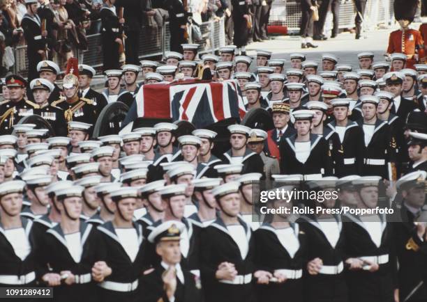 View of the ceremonial funeral of Lord Louis Mountbatten with the union flag draped coffin being transported on a gun carriage with a naval escort...