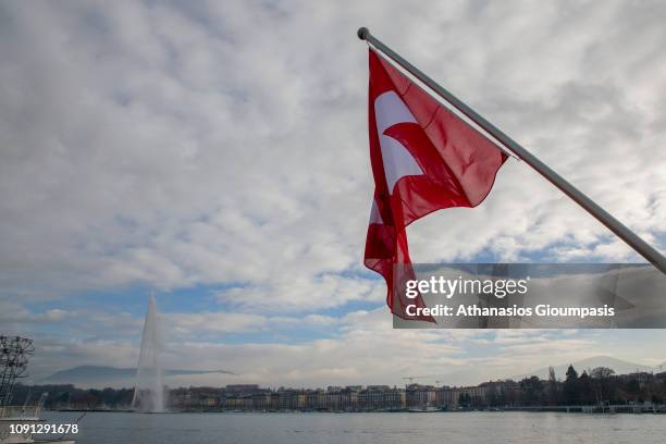Swiss flag and The fountain Jet d'Eau at Lake Geneva on December 31, 2018 in Geneva, Switzerland. The fountain Jet d'Eau is one of Geneva most famous...