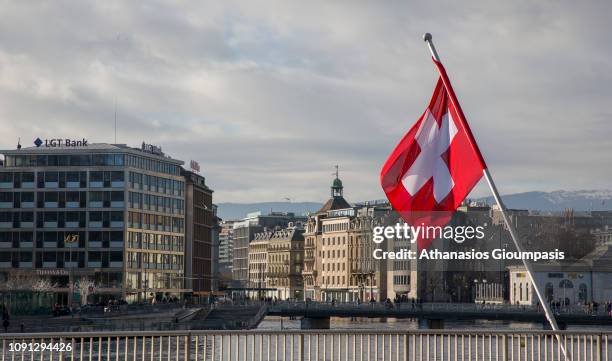 Swiss flag at Geneva Lake on December 31, 2018 in Geneva, Switzerland. Geneva is the second-most populous city in Switzerland and the most populous...