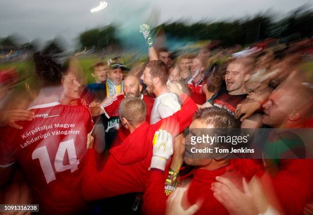 Karpatalya fans and players celebrate with the hero of the penalty shoot-out victory, goalkeeper Bela Fejer Csongor after the Northern Cyprus v...