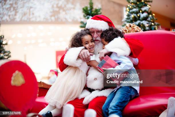 compras de navidad con la familia y papá noel en el centro comercial - papá noel fotografías e imágenes de stock