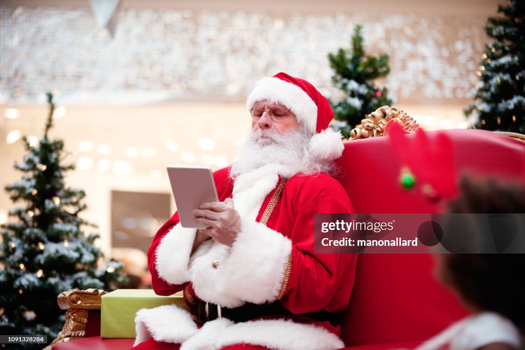 Shopping-Weihnachten mit der Familie und Santa Claus beim Einkaufszentrum
