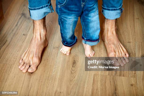 seção baixa de pai e filho estão com os pés descalços - barefoot men - fotografias e filmes do acervo