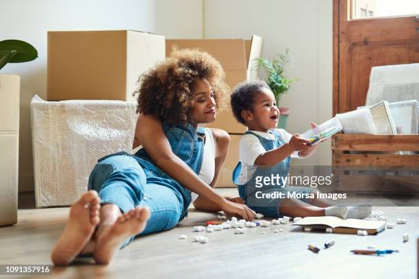 gelukkig moeder met dochter spelen in nieuwe woning - happy toddler stockfoto's en -beelden