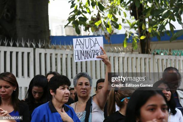 Woman holds a piece of paper with the expression in Spanish 'Humanitarian Help' outside Dr. JM de los Rios’ Children’s Hospital during a...