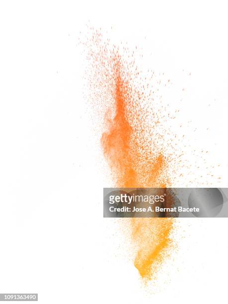 explosion by an impact of a cloud of particles of powder of color orange on a white background. - orange powder ストックフォトと画像
