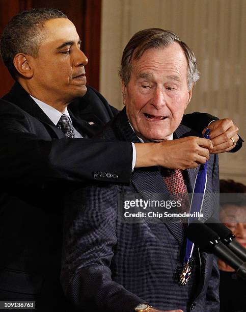 President Barack Obama presents former U.S. President George H.W. Bush with the 2010 Medal of Freedom in the East Room of the White House February...