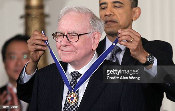 Investor Warren Buffett is presented with the 2010 Medal of Freedom by U.S. President Barack Obama during an East Room event at the White House...