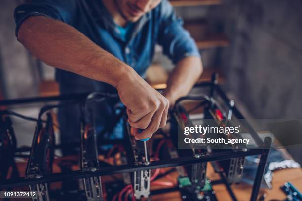 guy configures the computer for mining cryptocurrency - computer network support stock pictures, royalty-free photos & images