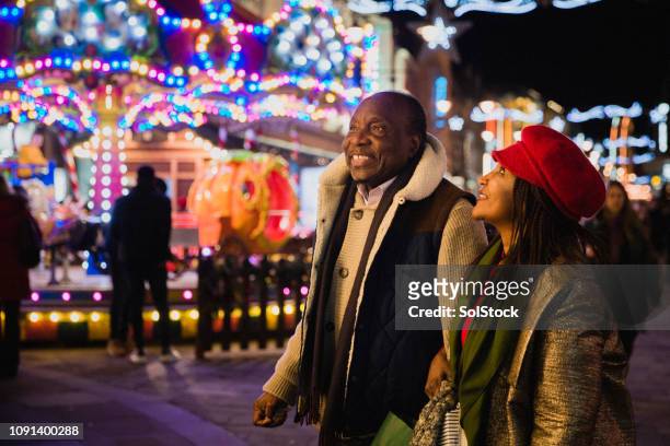 senior couple exploring christmas markets - shopping fun stock pictures, royalty-free photos & images