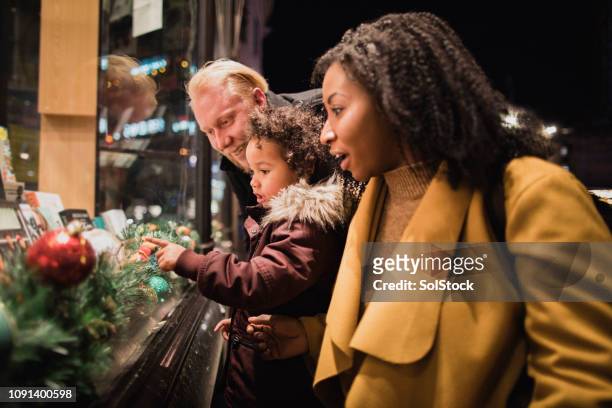 young girl choosing a gift for christmas - window shopping stock pictures, royalty-free photos & images