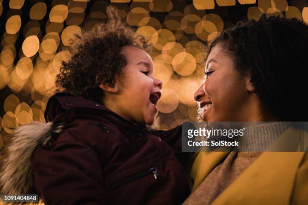 smiling in front of christmas lights - innocent stock pictures, royalty-free photos & images