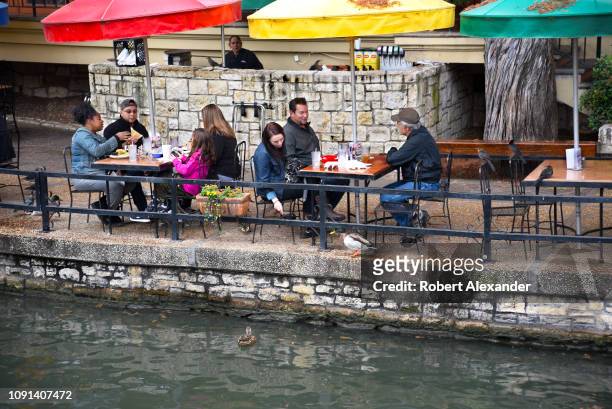 Restaurant customers enjoy their lunches beside the River Walk in downtown San Antonio, Texas.