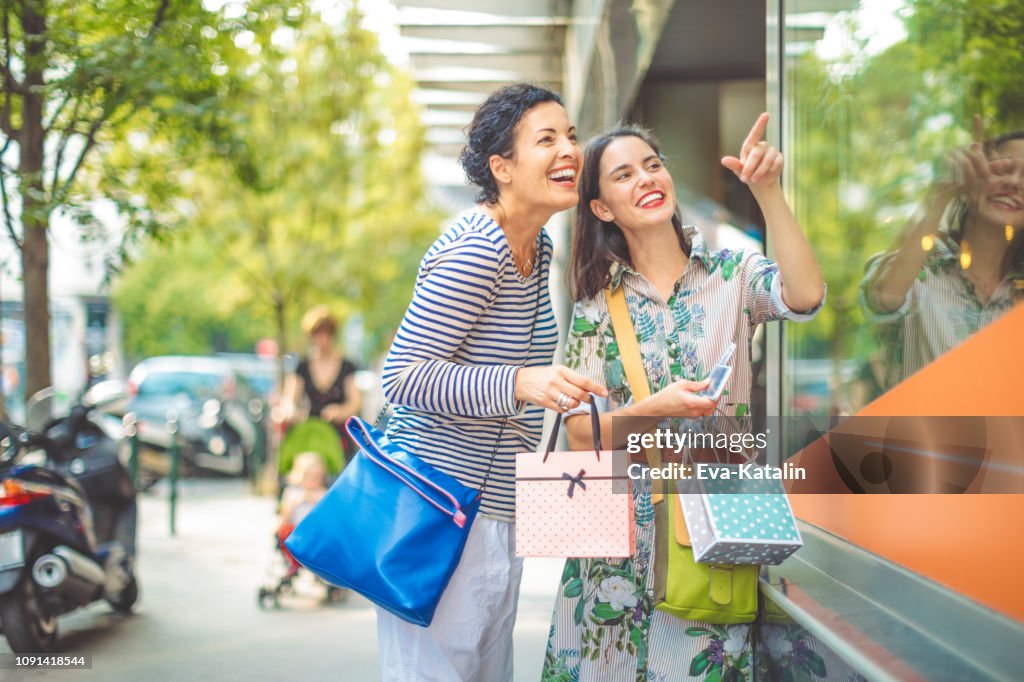 Mother and adult daughter are window shopping together