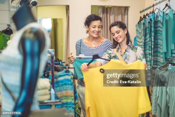 mother and her adult daughter are buying clothes - latin american and hispanic shopping bags stock pictures, royalty-free photos & images