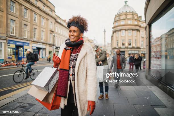 mature woman christmas shopping - christmas high street stock pictures, royalty-free photos & images