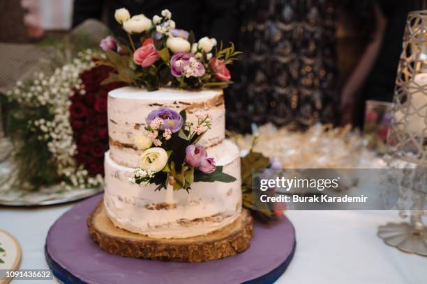 cooking, sweetness, wedding concept. close up of two tier amazing cake with white and brown streeps and decorated with flowers - wedding cakes stock pictures, royalty-free photos & images