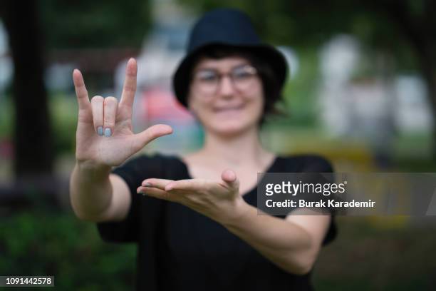young woman showing a sign - sign stock-fotos und bilder
