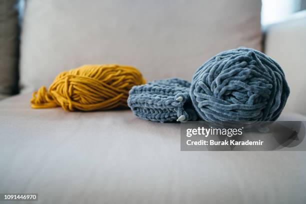 balls of woolen yarn on sofa - dicht stock-fotos und bilder