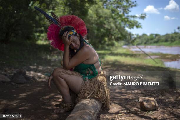 An indigenous woman from the Pataxo Ha-ha-hae community cries while looking at the Paraopeba river covered in mud, on the sixth day after the...