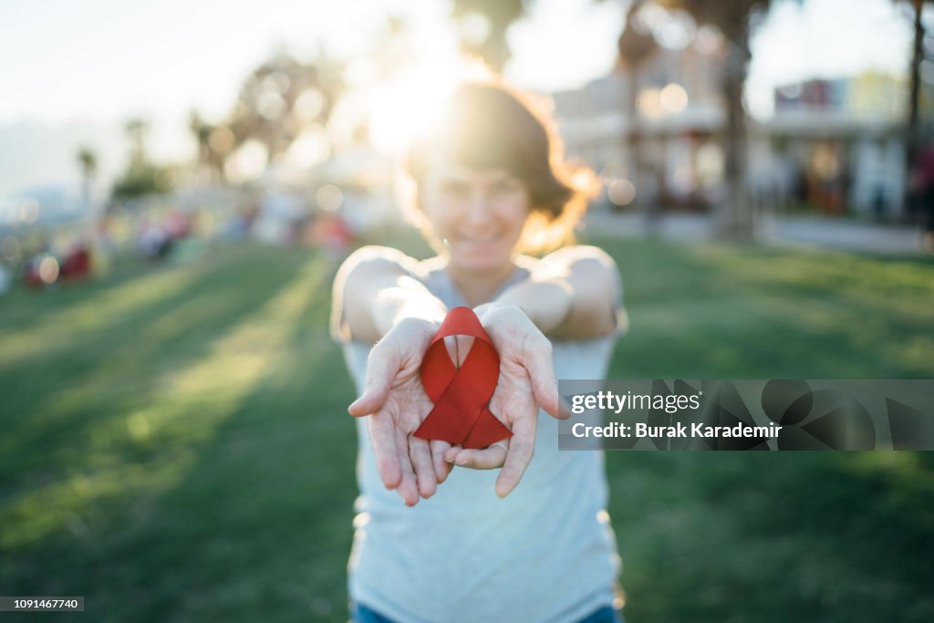 Young woman with red AIDS awareness ribbon