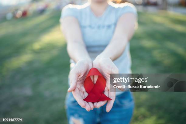 hands holding red aids awareness ribbon - world aids day 個照片及圖片檔