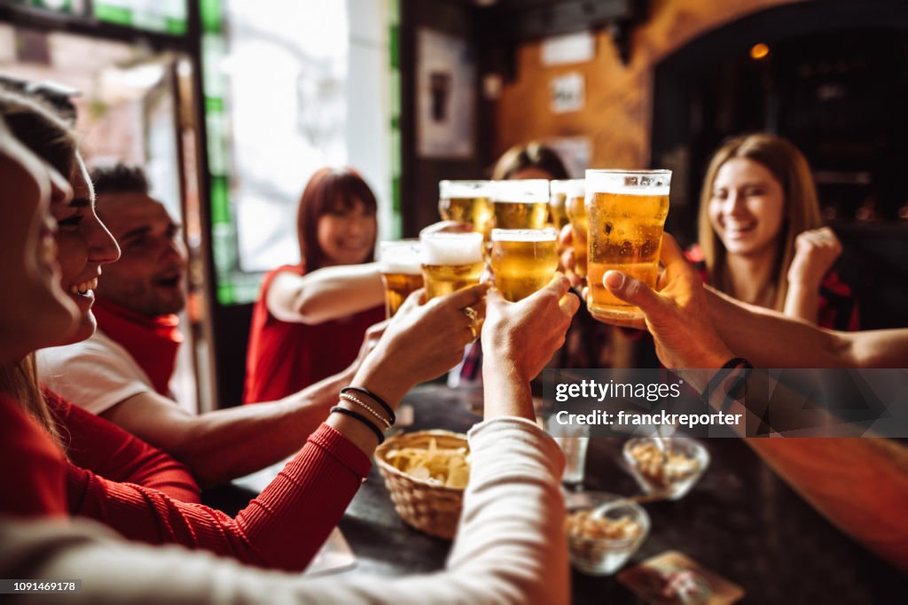 People talking and toasting in a pub with the beers