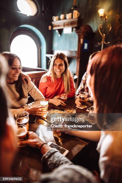 people talking indoors in a pub with the beers - italy beer stock pictures, royalty-free photos & images