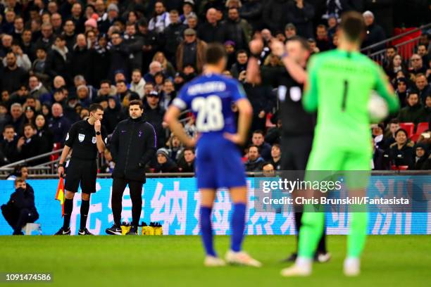 Manager of Tottenham Hotspur Mauricio Pochettino, looks on as Referee Michael Oliver indicates that he is using the VAR during the Carabao Cup Semi...