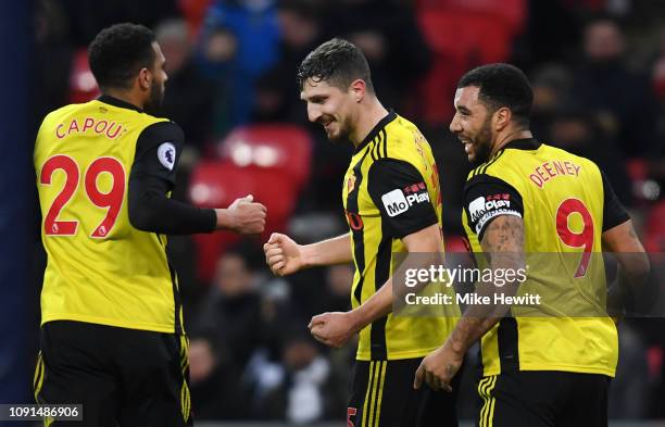 Craig Cathcart of Watford celebrates with teammates Etienne Capoue and Troy Deeney after scoring his team's first goal during the Premier League...