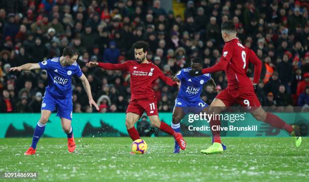 Mohamed Salah of Liverpool takes on Jonny Evans and Nampalys Mendy of Leicester City during the Premier League match between Liverpool FC and...