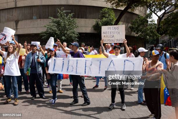 People shout slogans and hold a banner that reads 'Freedom' during a demonstration against the government of President Nicolás Maduro called by the...